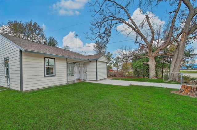 back of property with a patio area, fence, concrete driveway, and a yard