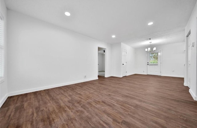 unfurnished room with recessed lighting, a notable chandelier, visible vents, baseboards, and dark wood-style floors