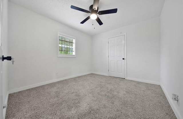 carpeted empty room featuring a ceiling fan, a textured ceiling, and baseboards