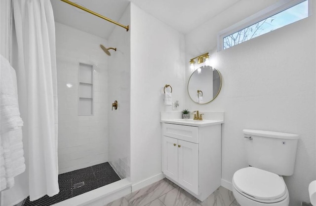 bathroom with baseboards, toilet, marble finish floor, a tile shower, and vanity