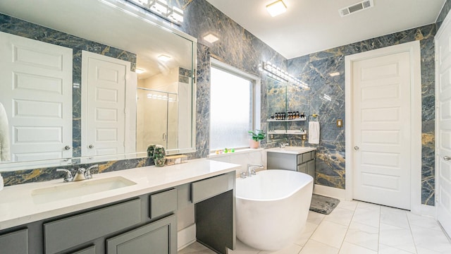 full bathroom featuring tile walls, visible vents, a freestanding bath, a shower stall, and vanity