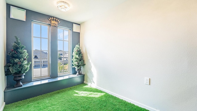 carpeted spare room featuring baseboards