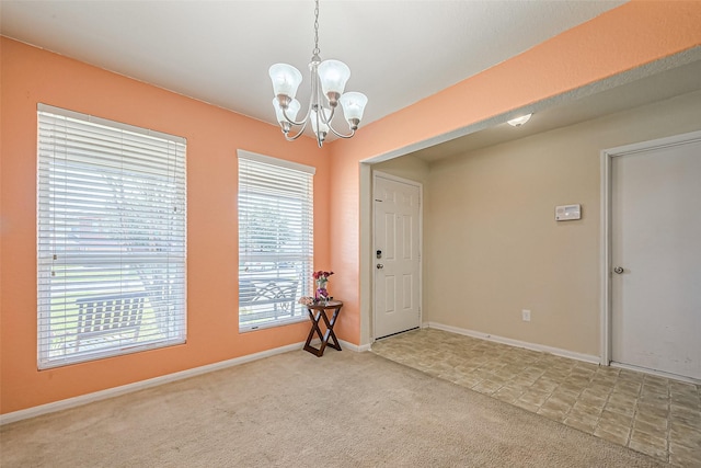 unfurnished room featuring carpet floors, baseboards, and a notable chandelier