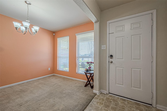 entryway with carpet floors, an inviting chandelier, and baseboards