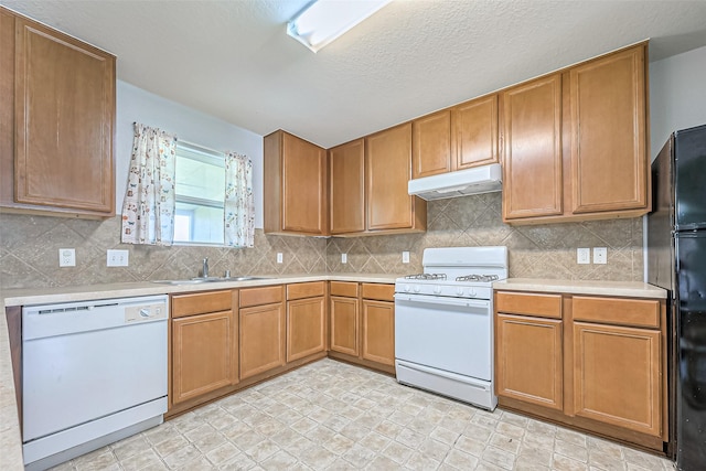 kitchen with white appliances, decorative backsplash, light countertops, under cabinet range hood, and a sink