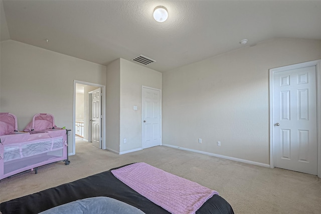 bedroom featuring lofted ceiling, baseboards, visible vents, and light colored carpet