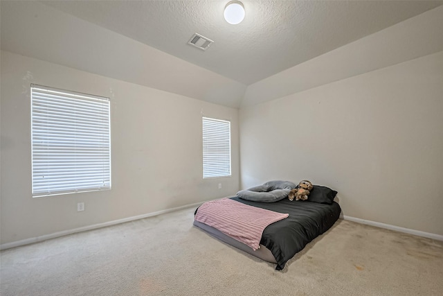 carpeted bedroom featuring lofted ceiling, multiple windows, visible vents, and baseboards