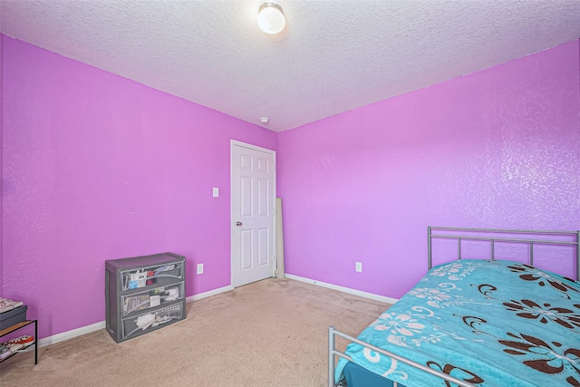 carpeted bedroom featuring a textured ceiling and baseboards