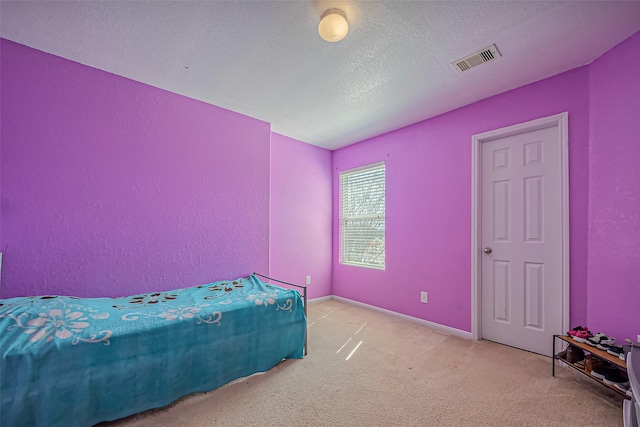 bedroom featuring carpet floors, visible vents, a textured ceiling, and baseboards