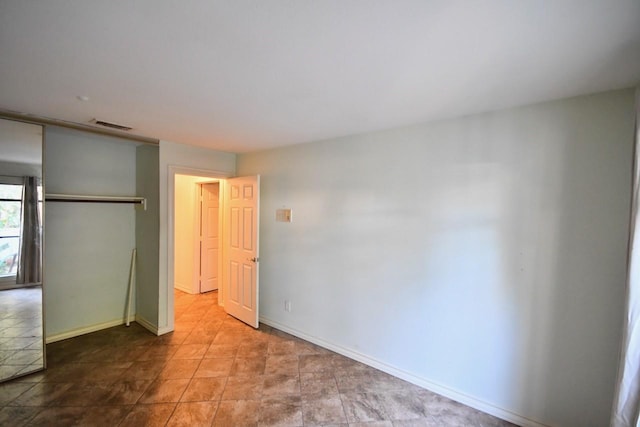 unfurnished bedroom featuring a closet, visible vents, and baseboards