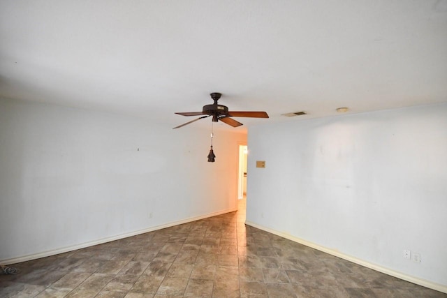 empty room with ceiling fan, visible vents, and baseboards