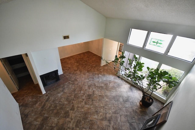 unfurnished living room with visible vents, a fireplace, and a textured ceiling