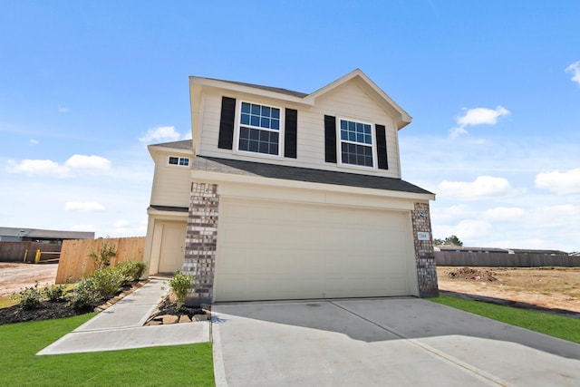 view of front of house with an attached garage, fence, and concrete driveway