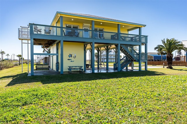 back of property featuring stairs, a yard, a carport, and a patio