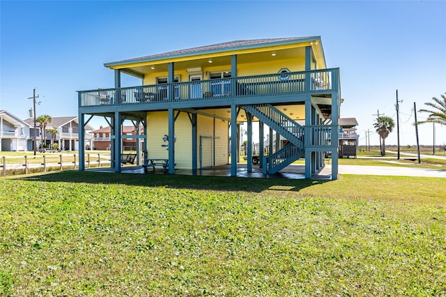 rear view of house featuring stairs, a yard, and a wooden deck