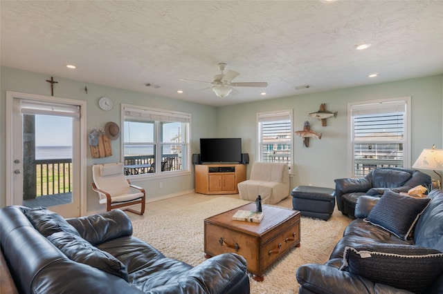 living area featuring ceiling fan, baseboards, a textured ceiling, and recessed lighting