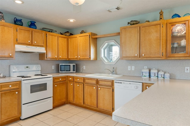 kitchen with light countertops, visible vents, a sink, white appliances, and under cabinet range hood