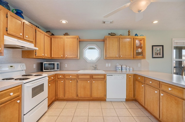 kitchen featuring under cabinet range hood, white appliances, a sink, and light countertops