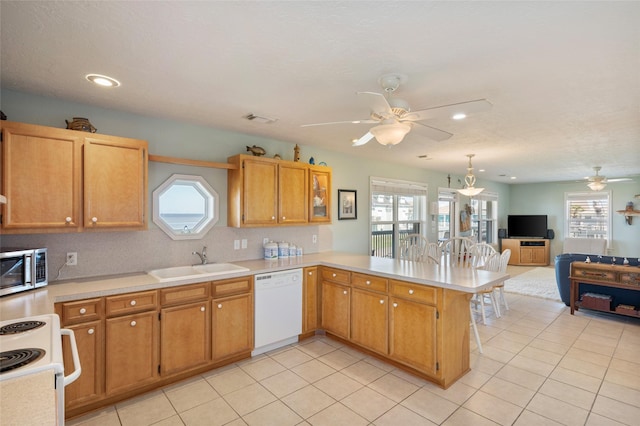 kitchen featuring white appliances, visible vents, light countertops, and a sink