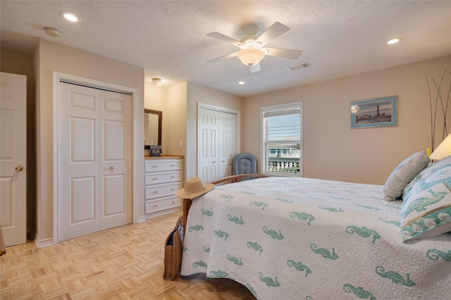 bedroom with two closets, recessed lighting, visible vents, a ceiling fan, and a textured ceiling