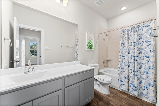 full bathroom featuring shower / tub combo, visible vents, toilet, wood finished floors, and vanity