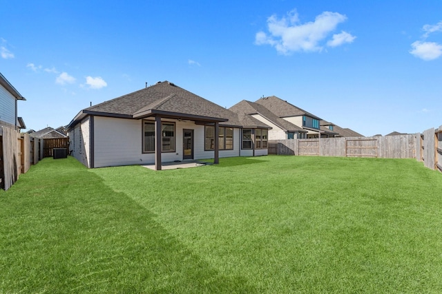 back of house with a fenced backyard and a lawn