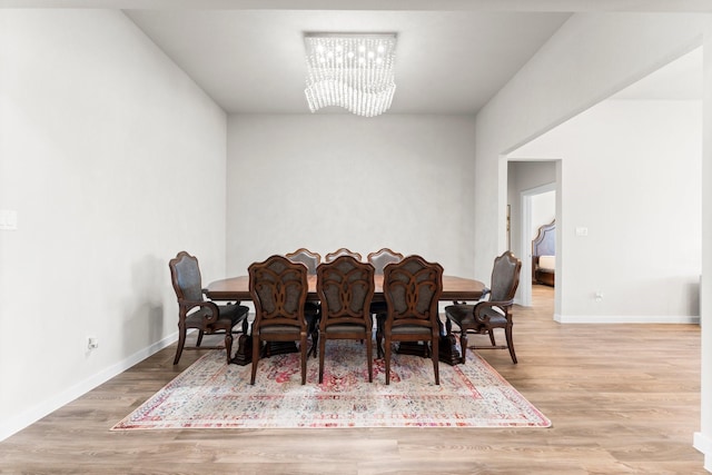 dining room with a chandelier, wood finished floors, and baseboards