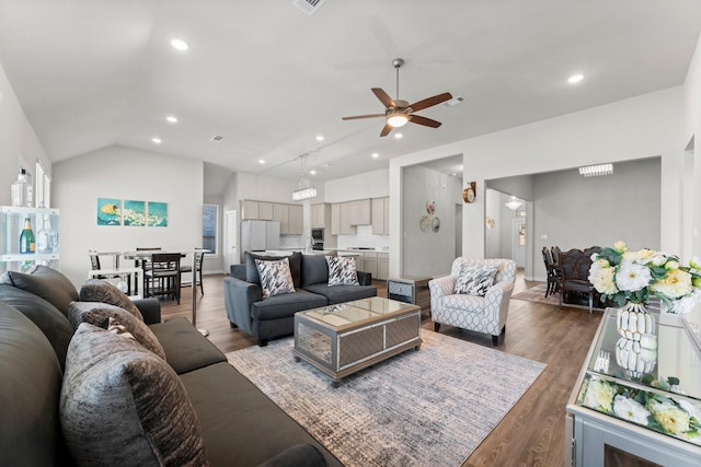 living room featuring lofted ceiling, a ceiling fan, wood finished floors, and recessed lighting