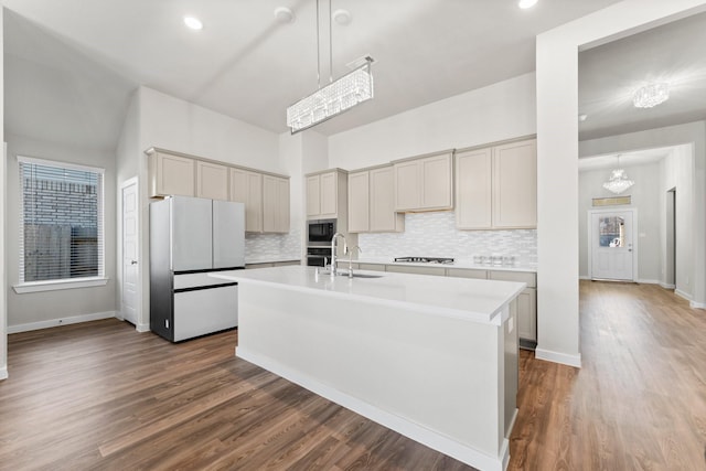 kitchen featuring cooktop, built in microwave, light countertops, and freestanding refrigerator