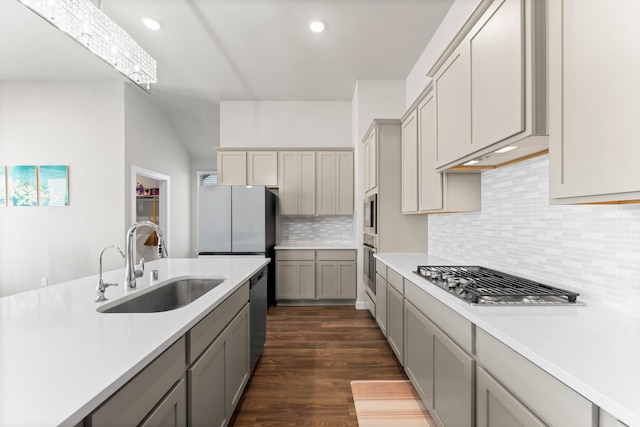 kitchen with stainless steel appliances, light countertops, a sink, and gray cabinetry