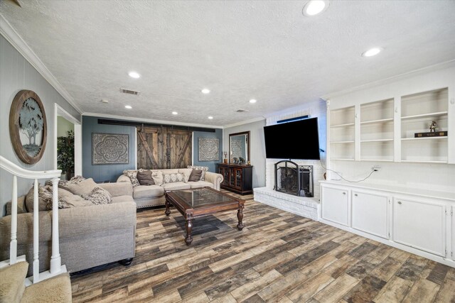 5502 Enchanted Timbers Dr, Humble, TX 77346 - living area featuring ornamental molding, wood finished floors, recessed lighting, a fireplace, and a textured ceiling