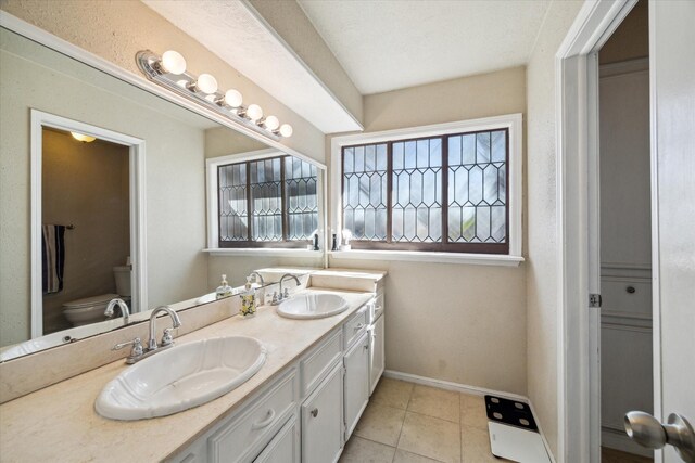 5502 Enchanted Timbers Dr, Humble, TX 77346 - bathroom featuring toilet, double vanity, baseboards, and tile patterned floors