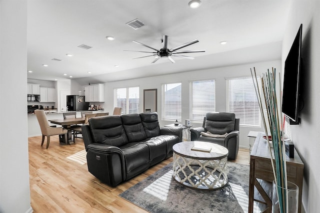 living area featuring light wood-style flooring, visible vents, and recessed lighting