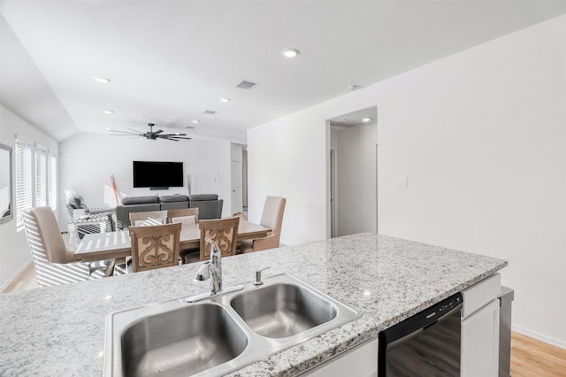 kitchen with black dishwasher, visible vents, light wood-style flooring, white cabinetry, and a sink