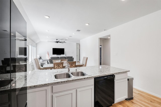 kitchen featuring dishwasher, light stone counters, a sink, and white cabinets