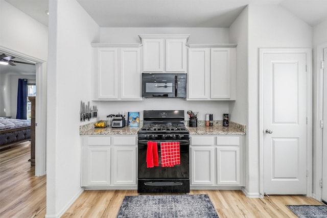 kitchen featuring white cabinets, light wood-style flooring, black appliances, and light stone countertops