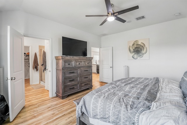 bedroom with a ceiling fan, light wood-type flooring, visible vents, and lofted ceiling