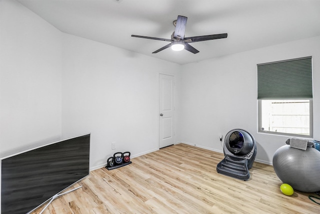 workout room with a ceiling fan, baseboards, and wood finished floors