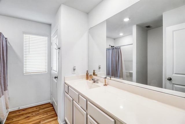 full bath featuring baseboards, visible vents, a shower with shower curtain, wood finished floors, and vanity