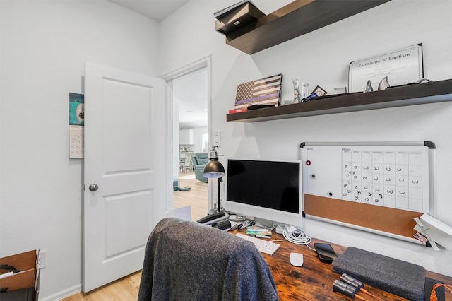 office area with mail area, baseboards, and wood finished floors