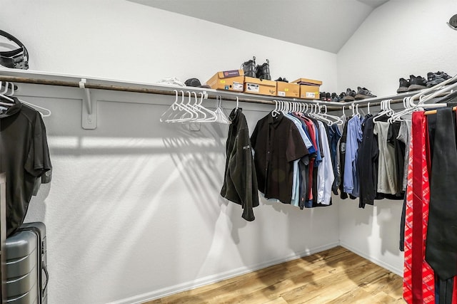 spacious closet with vaulted ceiling and wood finished floors