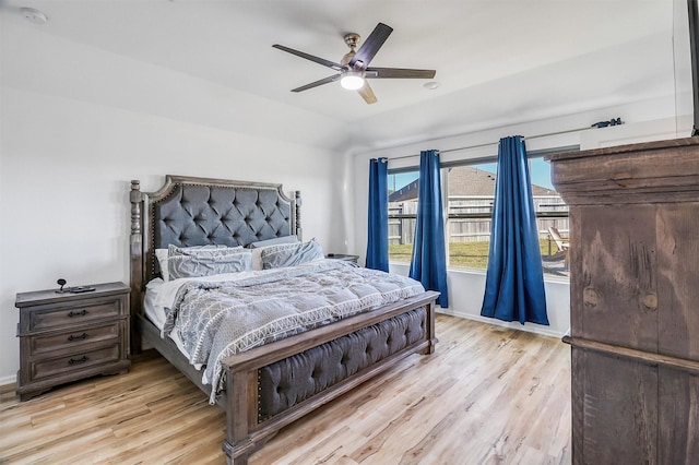 bedroom featuring lofted ceiling, ceiling fan, baseboards, and light wood-style floors