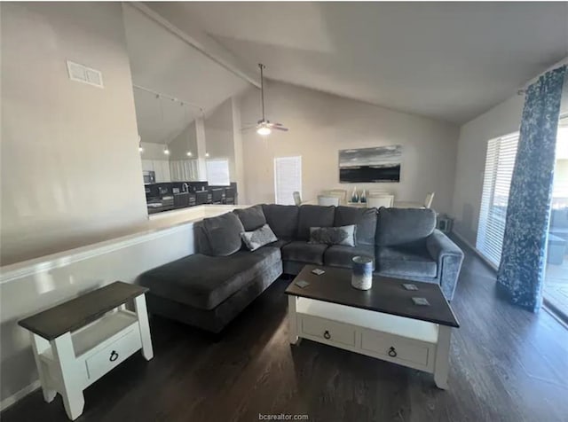 living room with dark wood-type flooring, visible vents, vaulted ceiling with beams, and a ceiling fan