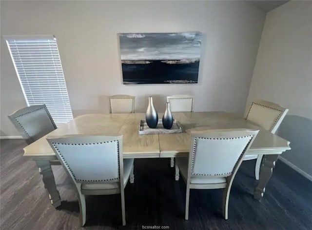 dining space featuring baseboards and wood finished floors