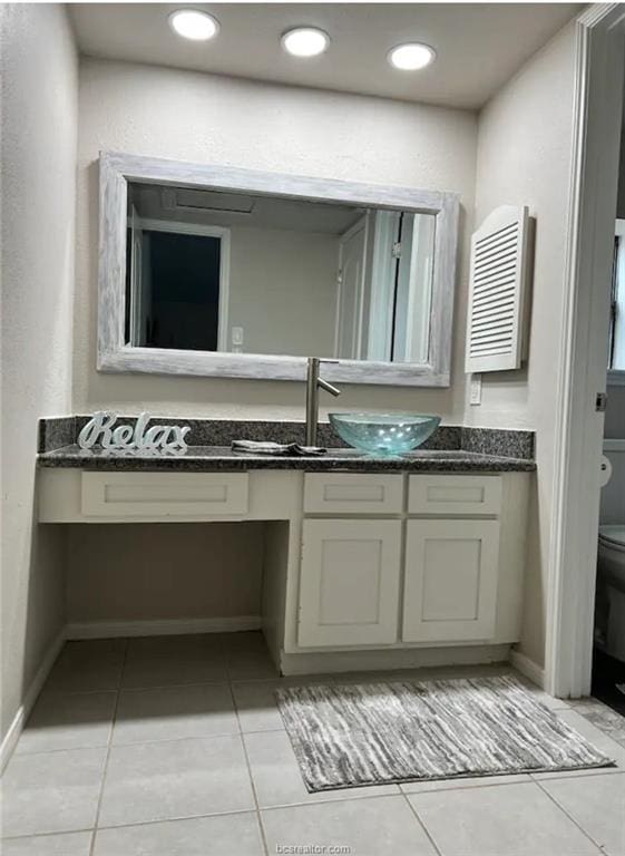 bathroom with toilet, tile patterned flooring, baseboards, and vanity