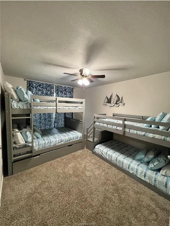 bedroom featuring a textured ceiling, carpet flooring, and a ceiling fan