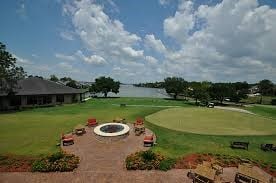 view of home's community with a water view, a yard, and a fire pit