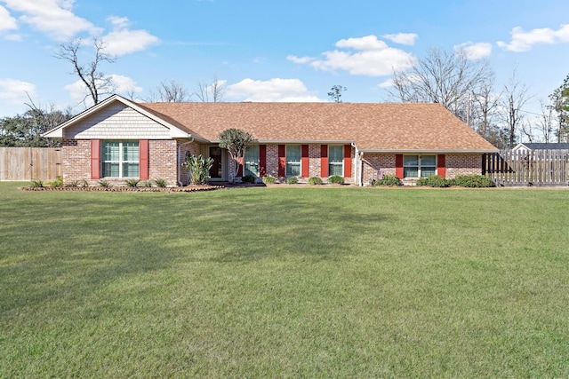 ranch-style house featuring brick siding, a front yard, and fence