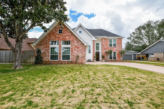 traditional-style home with fence, a front lawn, and brick siding