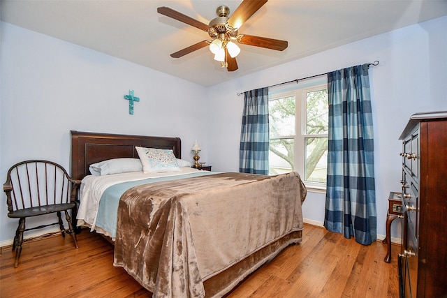 bedroom featuring baseboards, a ceiling fan, and light wood-style floors